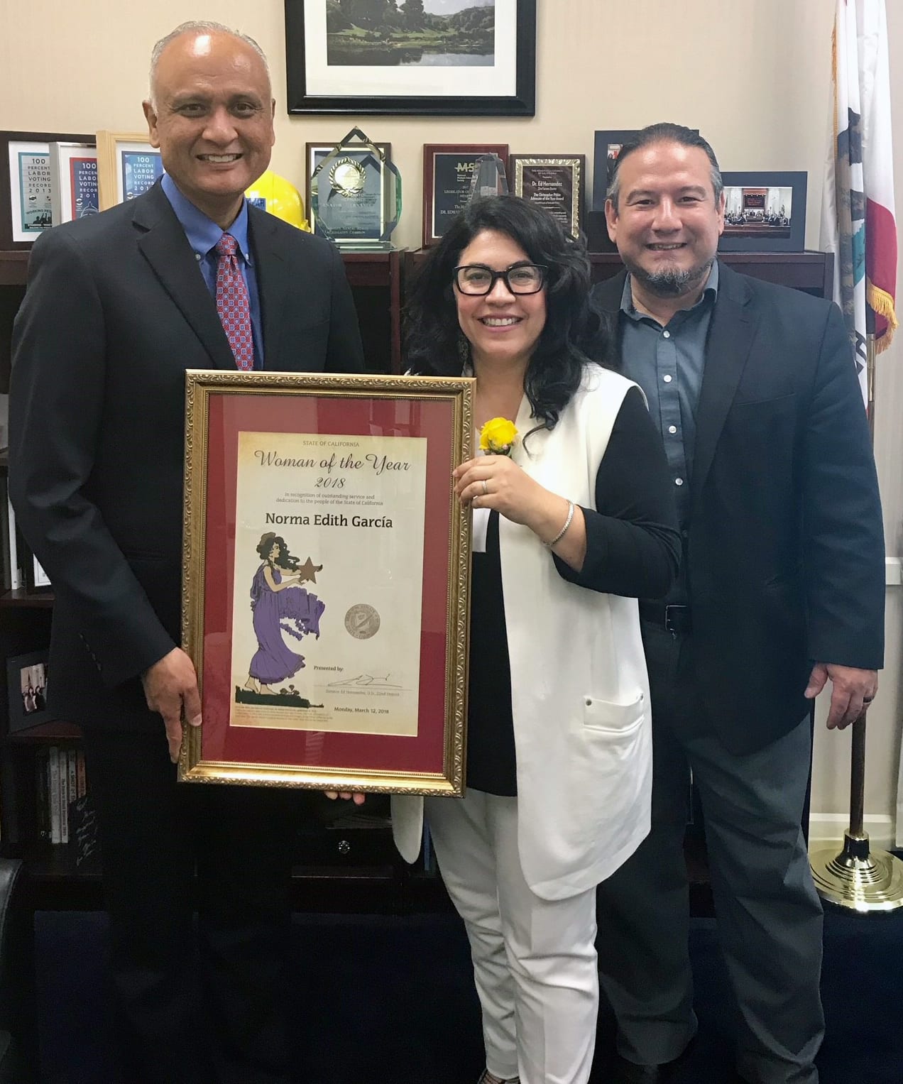 A picture of two people holding an award.