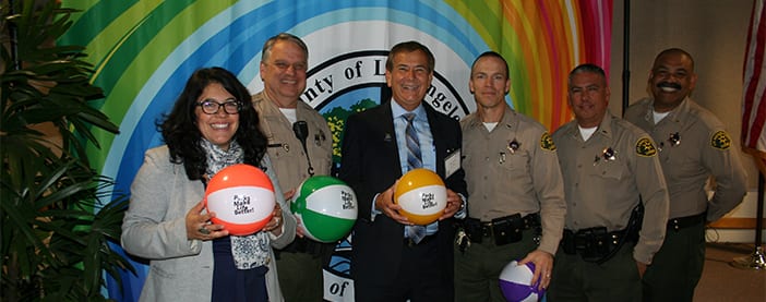 Park and Recs director at an event with multiple sheriffs holding beach balls