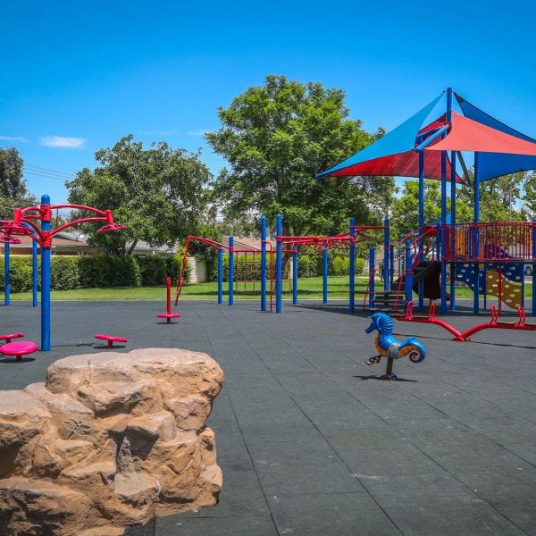 Playground with a small rock structure and jungle gym