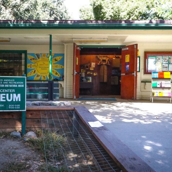 Nature center museum, exterior view, showing planter and signs