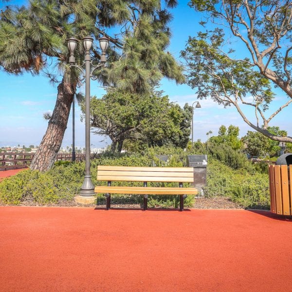 Red exercise track, bench and trash can