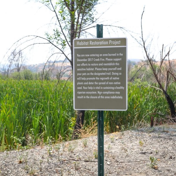 Habitat Restoration Project sign amongst the tall grass