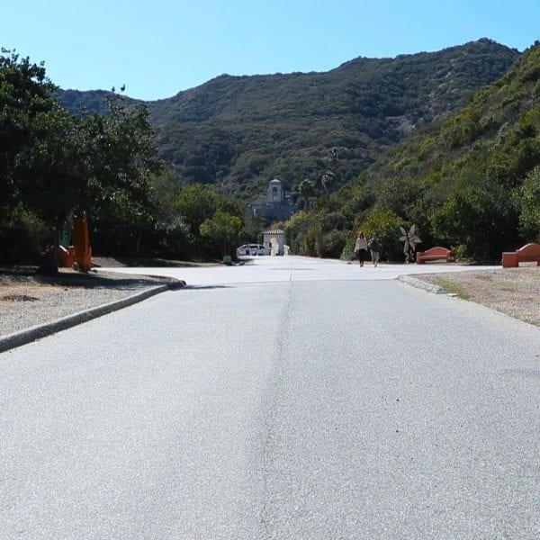 Paved road to a mission building structure and big hills